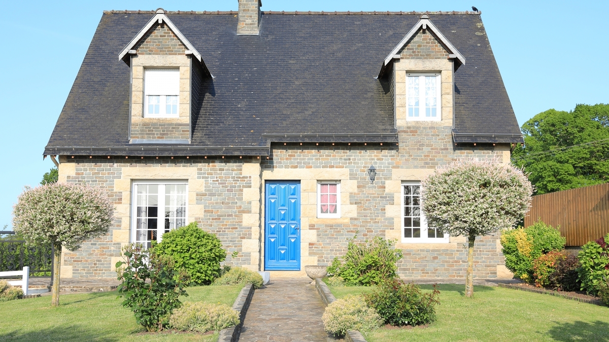 Maison normande avec son toit typique en ardoise.